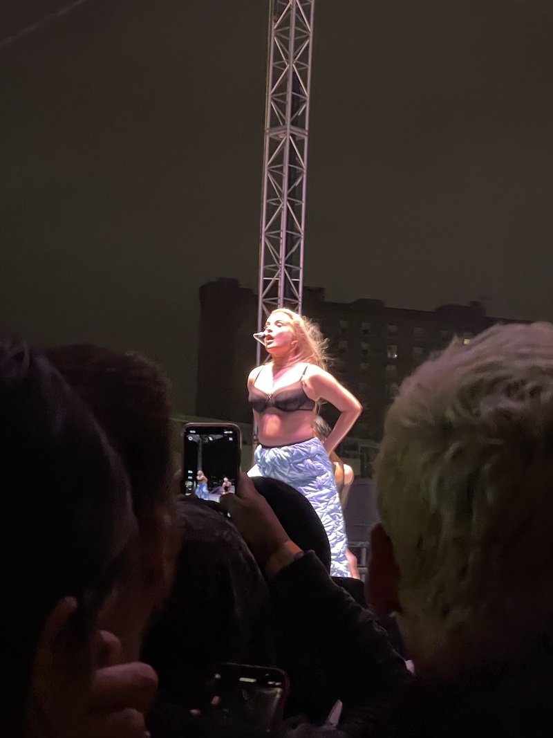 Kim Petras on stage, singing into the rain